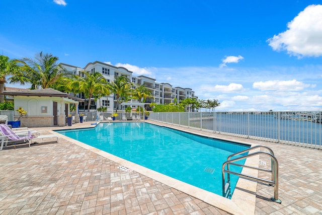 view of swimming pool featuring a patio area and a water view