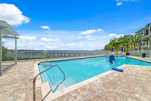 view of swimming pool with a patio and a water view