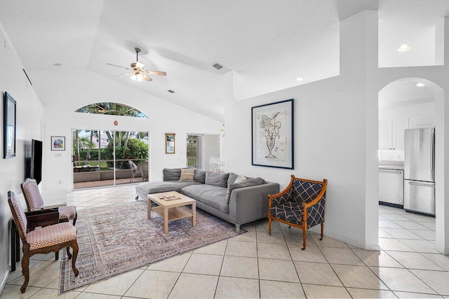 tiled living room with ceiling fan, high vaulted ceiling, and a textured ceiling