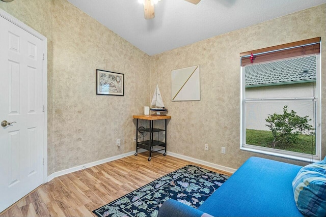 sitting room with ceiling fan and wood-type flooring