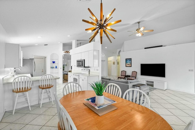 dining area featuring light tile patterned floors, ceiling fan with notable chandelier, and lofted ceiling