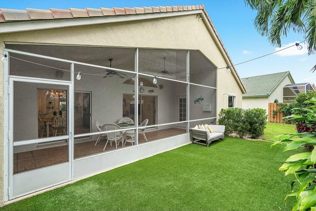 1643 Oak Berry Cir, Wellington, FL 33414 - rear view of property with a yard, a ceiling fan, stucco siding, a tile roof, and a sunroom