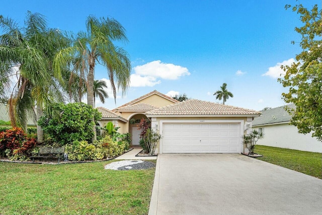 1643 Oak Berry Cir, Wellington, FL 33414 - mediterranean / spanish-style home with stucco siding, an attached garage, a tiled roof, driveway, and a front yard