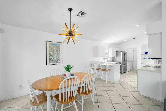 dining area featuring an inviting chandelier, light tile patterned floors, and vaulted ceiling