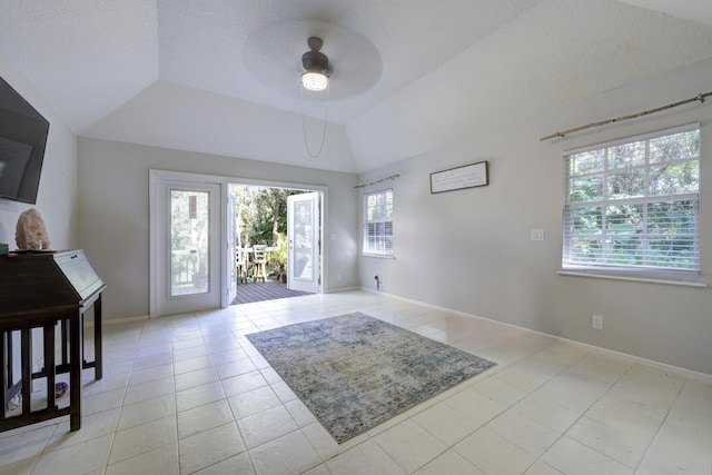 interior space featuring ceiling fan, plenty of natural light, and vaulted ceiling