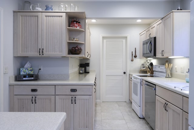 kitchen featuring white range with electric cooktop, light tile patterned flooring, and stainless steel dishwasher