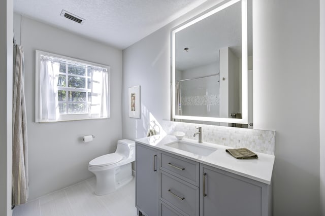 bathroom with tasteful backsplash, vanity, a textured ceiling, tile patterned flooring, and toilet