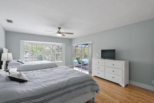 bedroom with ceiling fan, a textured ceiling, access to outside, and light hardwood / wood-style flooring