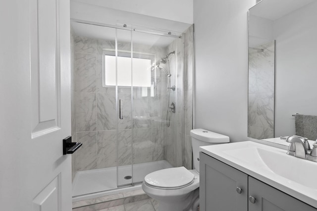 bathroom with vanity, toilet, and a shower with door