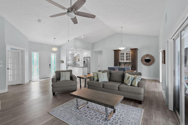 living room featuring a textured ceiling, dark hardwood / wood-style floors, and ceiling fan