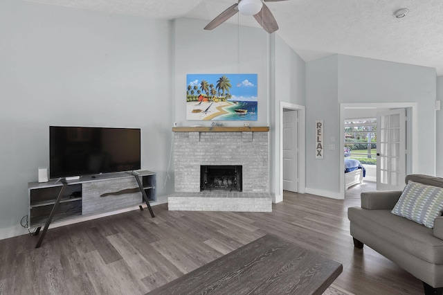 living room with ceiling fan, high vaulted ceiling, hardwood / wood-style floors, a textured ceiling, and a fireplace