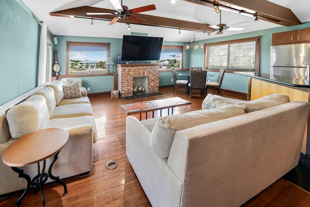 living room with hardwood / wood-style flooring, lofted ceiling, and a wealth of natural light