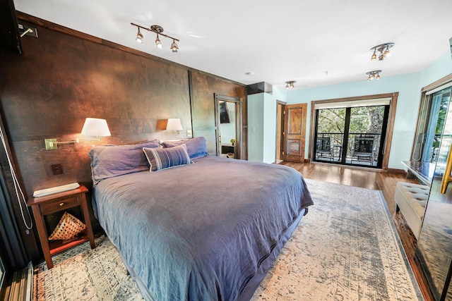 bedroom featuring access to exterior and light hardwood / wood-style flooring