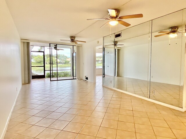 6928 Briarlake Cir Unit 104, Palm Beach Gardens, FL 33418 - spare room featuring light tile patterned flooring, healthy amount of natural light, and ceiling fan
