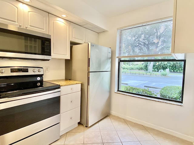 6928 Briarlake Cir Unit 104, Palm Beach Gardens, FL 33418 - kitchen featuring appliances with stainless steel finishes, white cabinets, baseboards, light tile patterned floors, and light countertops