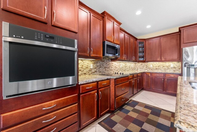 kitchen featuring sink, stainless steel appliances, decorative backsplash, decorative light fixtures, and a kitchen island with sink