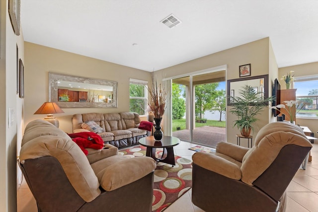 tiled living room featuring a water view