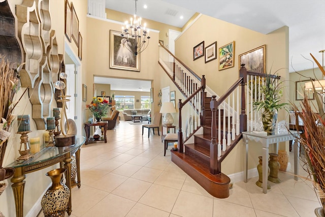 tiled foyer entrance featuring a towering ceiling and an inviting chandelier