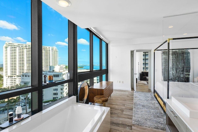 bathroom featuring floor to ceiling windows, a washtub, and wood-type flooring