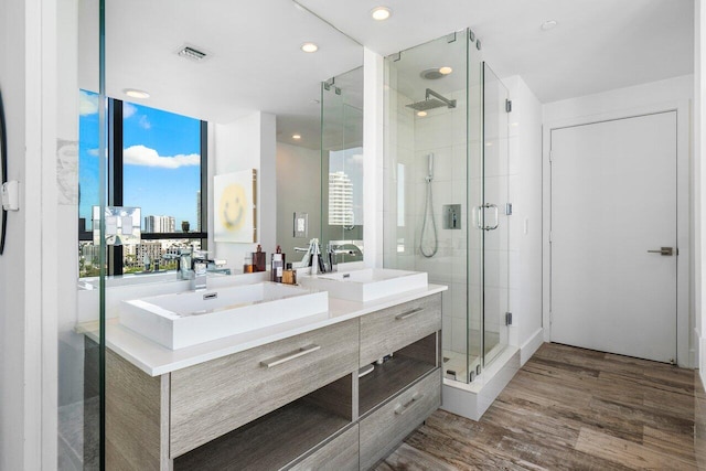 bathroom featuring vanity, wood-type flooring, and walk in shower