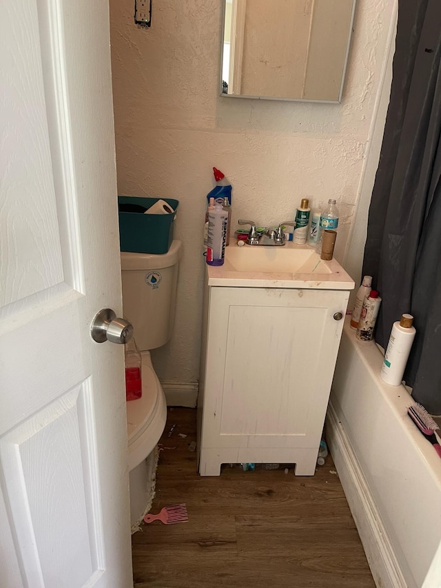 bathroom featuring hardwood / wood-style flooring, vanity, and toilet