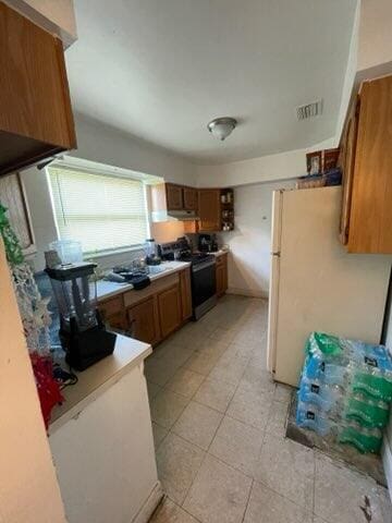 kitchen with white refrigerator and stainless steel electric stove