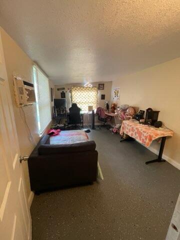 bedroom featuring a wall mounted air conditioner and a textured ceiling