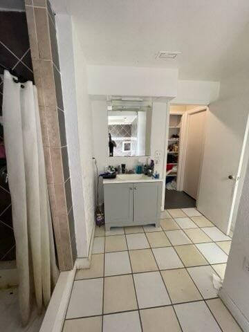 bathroom featuring vanity, tile patterned floors, and walk in shower