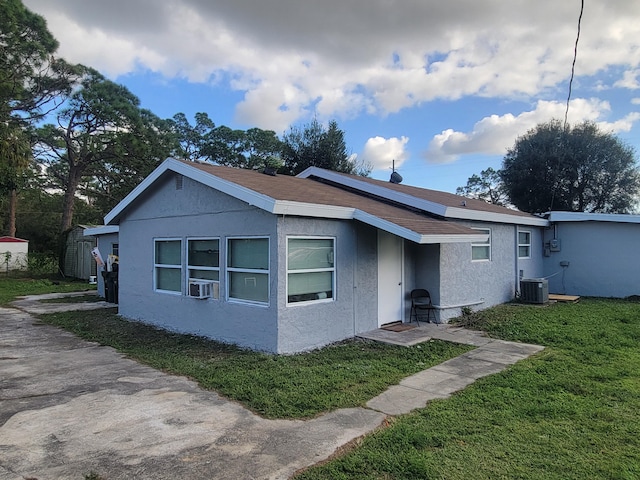 view of front of home featuring a front yard, central AC unit, and cooling unit