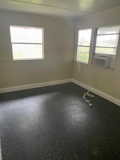 unfurnished room featuring a paneled ceiling and plenty of natural light