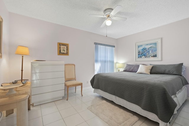 tiled bedroom featuring ceiling fan and a textured ceiling