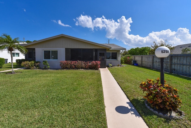 view of front of property with a front lawn and fence