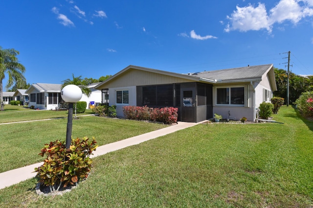 ranch-style home with a front yard and a sunroom