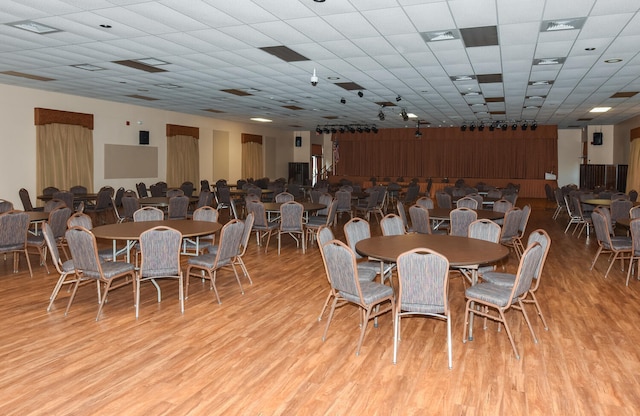 dining area with light hardwood / wood-style floors and a drop ceiling