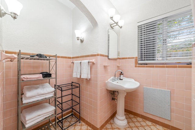 bathroom featuring tile patterned flooring and tile walls