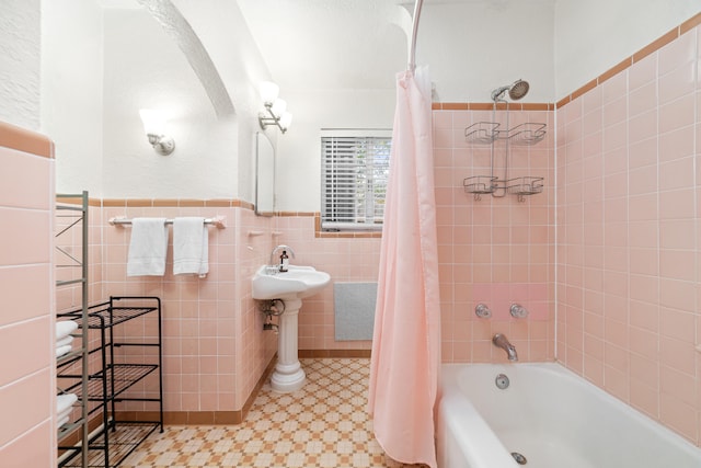 bathroom featuring shower / bathtub combination with curtain and tile walls