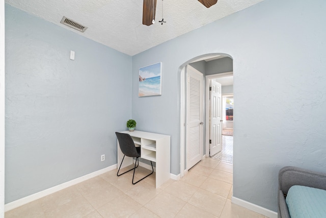 office space featuring ceiling fan, light tile patterned flooring, and a textured ceiling