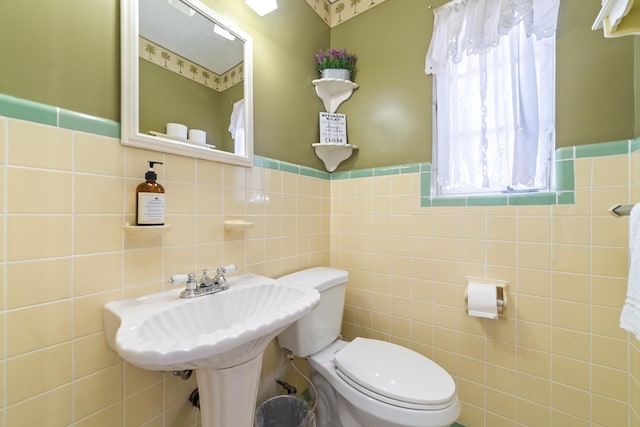 bathroom featuring toilet and tile walls