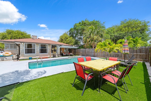 view of pool with a patio area and a yard