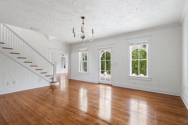 foyer with a chandelier, a textured ceiling, hardwood / wood-style flooring, and ornamental molding