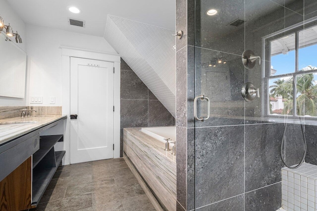 bathroom with vanity, shower with separate bathtub, and tile walls