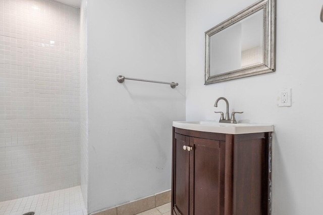 bathroom with tile patterned floors, vanity, and tiled shower