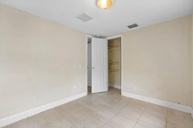 unfurnished bedroom with a closet and light tile patterned flooring