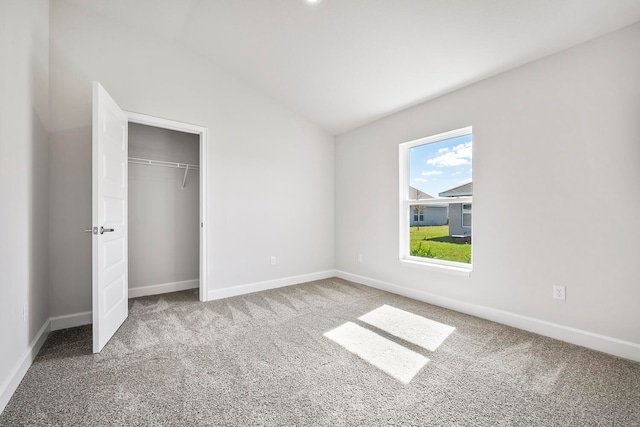 unfurnished bedroom featuring carpet flooring and vaulted ceiling