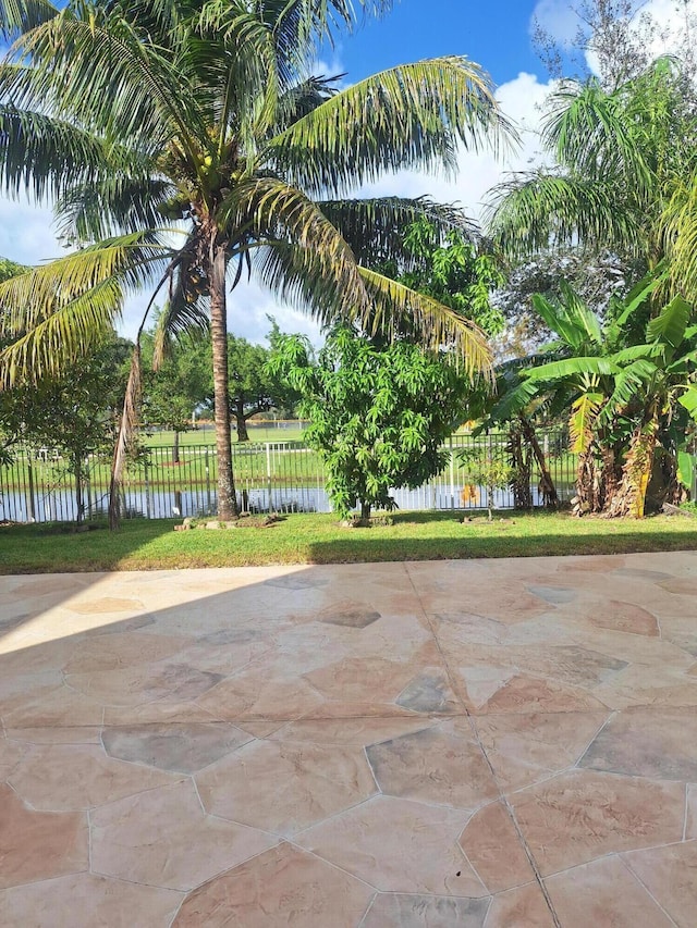 surrounding community with a patio area and a water view