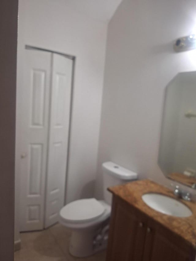 bathroom featuring tile patterned flooring, vanity, and toilet