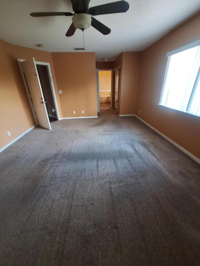 carpeted spare room with ceiling fan