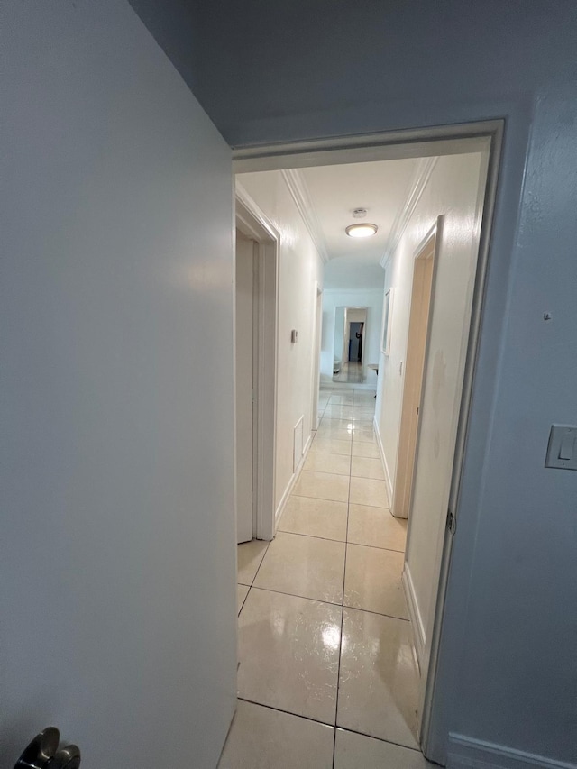 hallway with light tile patterned floors and ornamental molding