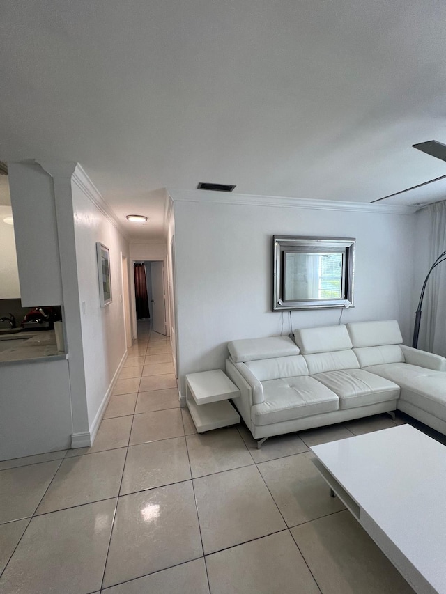 unfurnished living room with sink, ornamental molding, and light tile patterned flooring