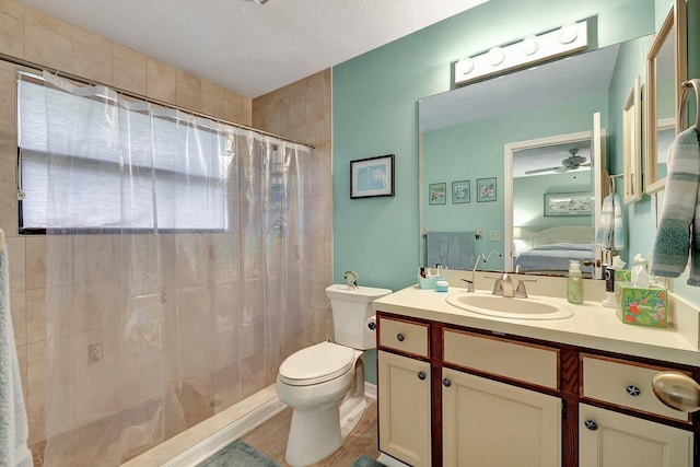 bathroom with ceiling fan, hardwood / wood-style floors, a textured ceiling, toilet, and vanity